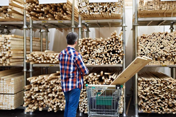 Man kiest en koopt van houten planken in de winkel — Stockfoto