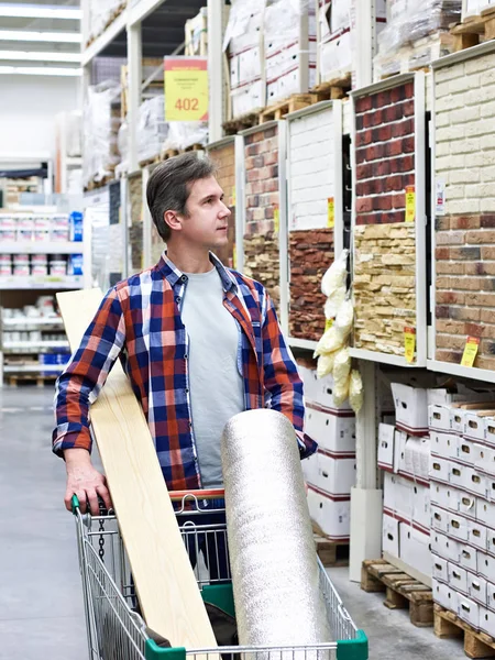 Man chooses and buys goods in store — Stock Photo, Image