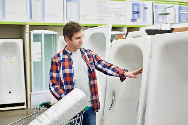 L'uomo sceglie il bagno di casa nel negozio di costruzione — Foto Stock