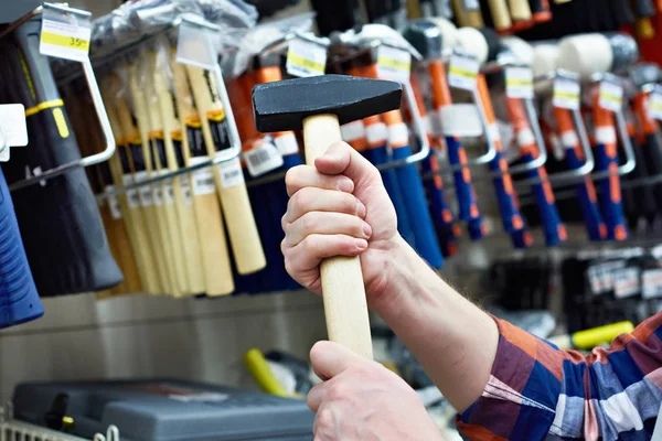 Main avec marteau dans le magasin de construction — Photo