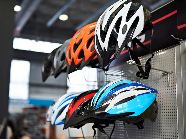 Cascos deportivos protectores modernos para ciclistas en tienda —  Fotos de Stock