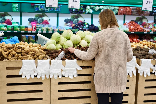 Femme sélectionne des légumes à l'épicerie — Photo