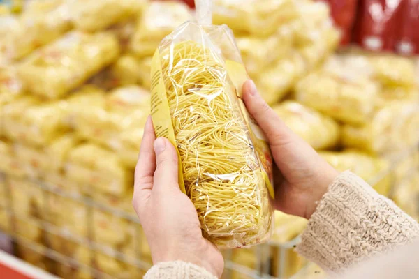 Pacco di spaghetti in mani di compratore a deposito — Foto Stock