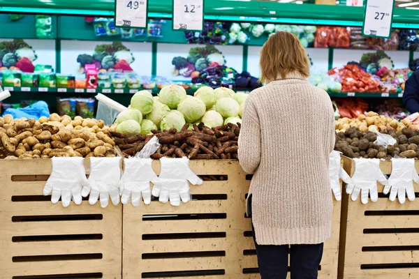 Femme sélectionne des légumes à l'épicerie — Photo