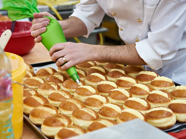 Konditor bereitet Brötchen mit Sahne zu — Stockfoto