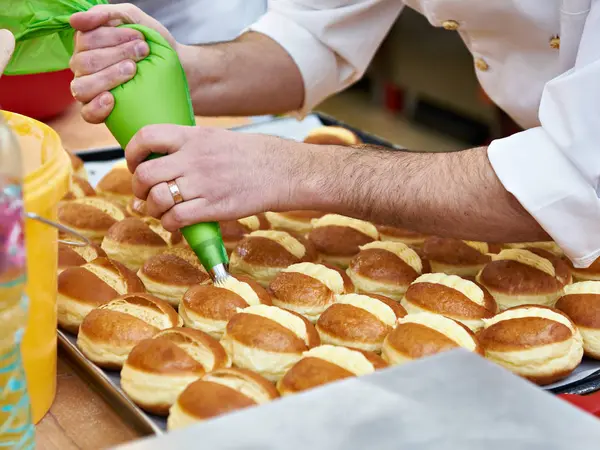 Konditor bereitet Brötchen mit Sahne zu — Stockfoto