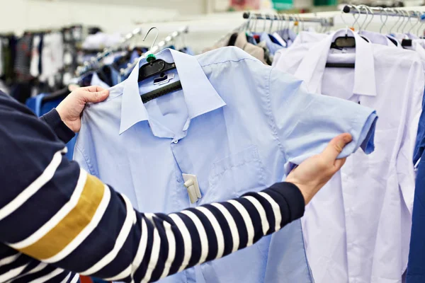 Hombre elige camisa en tienda — Foto de Stock