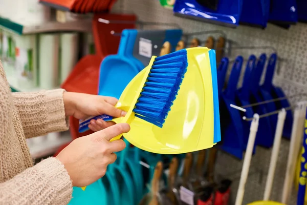 Manos de mujer con cepillo de limpieza y cuchara en la tienda —  Fotos de Stock