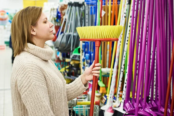 女性が店の床ブラシを選択します。 — ストック写真