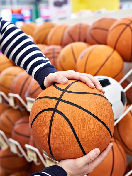 Comprador mãos com basquete na loja de desporto — Fotografia de Stock