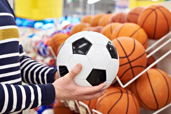 Τα χέρια του αγοραστή με το ποδόσφαιρο και το μπάσκετ στο κατάστημα αθλητικών ειδών — Φωτογραφία Αρχείου
