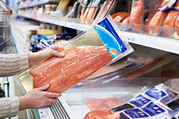 Vrouw koopt licht gezouten rode vis in opslag — Stockfoto