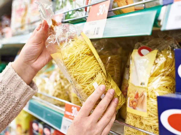 Pacco di pasta in mani di compratore a deposito — Foto Stock