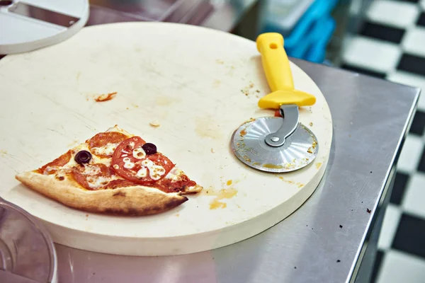 Pedazo de pizza de queso con tomates y un cuchillo redondo — Foto de Stock