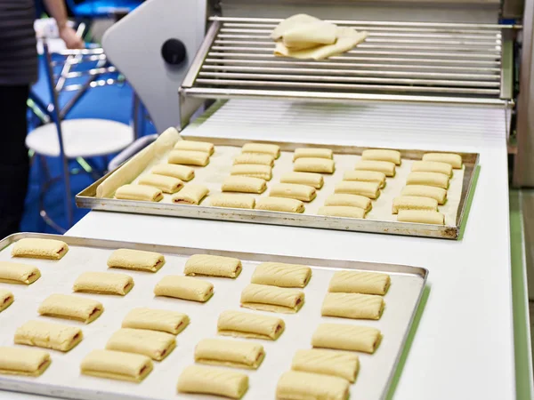 Pasteles en el transportador de pastelería para hornear — Foto de Stock