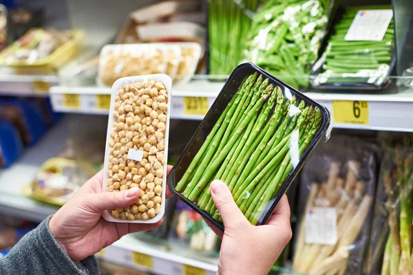 Mani con asparagi e piselli germogliati in negozio — Foto Stock