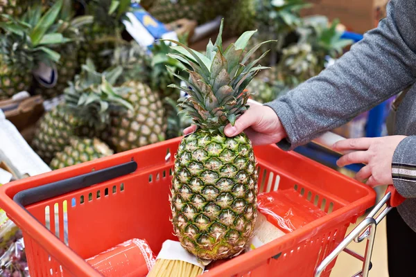 Mujer compra piña en tienda de comestibles — Foto de Stock