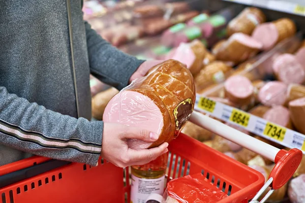 Acquirente con salsiccia nel cestino in negozio — Foto Stock