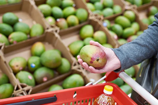 Манго фрукты в покупатели рука в продуктовом магазине — стоковое фото