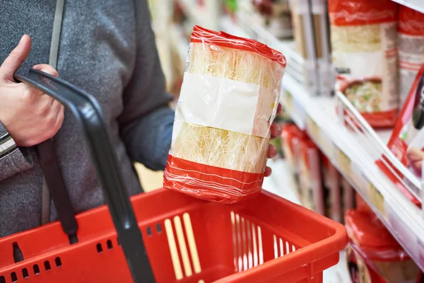 Imballaggio tagliatelle cinesi fini e carrello della spesa — Foto Stock