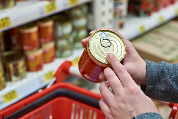 Tin can in hands of buyer — Stock Photo, Image