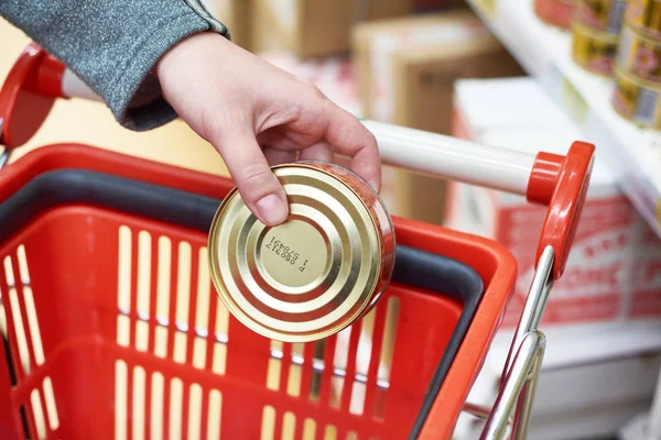 Tin can in hands of buyer — Stock Photo, Image