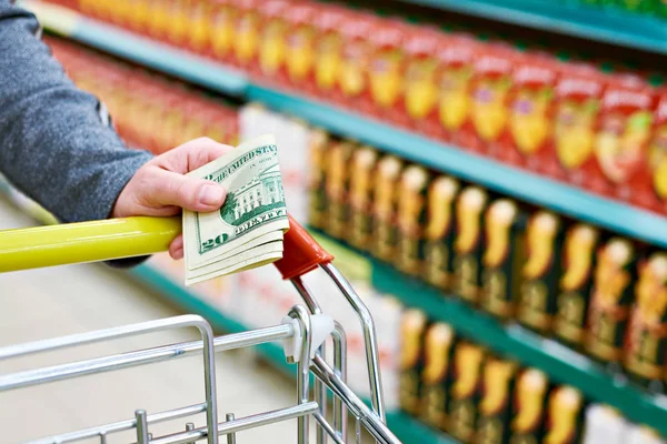 Billetes de dólar en mano en la tienda — Foto de Stock