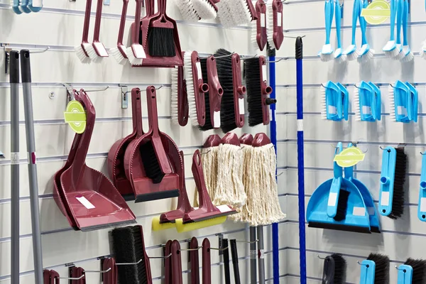 Plastic household brushes, scoops and mops in store — Stock Photo, Image