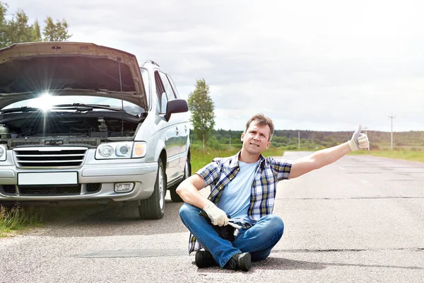 Man met duimen in de buurt van zijn kapotte auto — Stockfoto