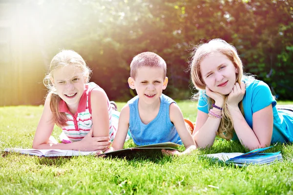 Děti čtou knihu o trávě — Stock fotografie