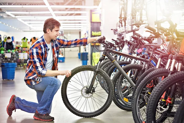 Man checks bicycle in shop — Stock Photo, Image