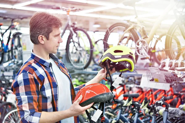 Hombre elige casco para el ciclismo —  Fotos de Stock