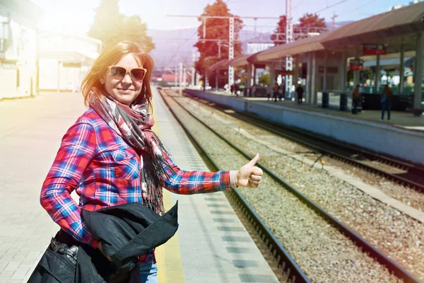 Vrouw duimen omhoog op het station — Stockfoto