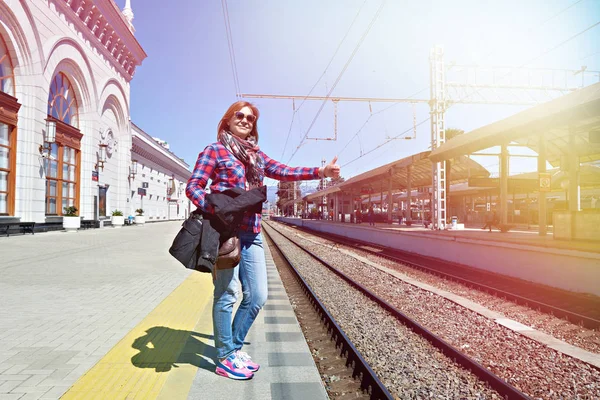 Felice donna pollice in su sulla stazione ferroviaria — Foto Stock