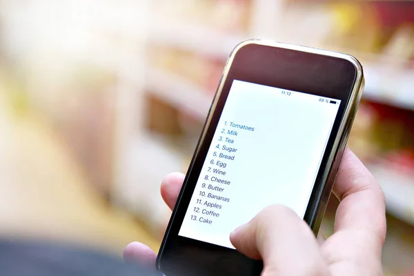 Shopping list on smartphone in hand of customer — Stock Photo, Image