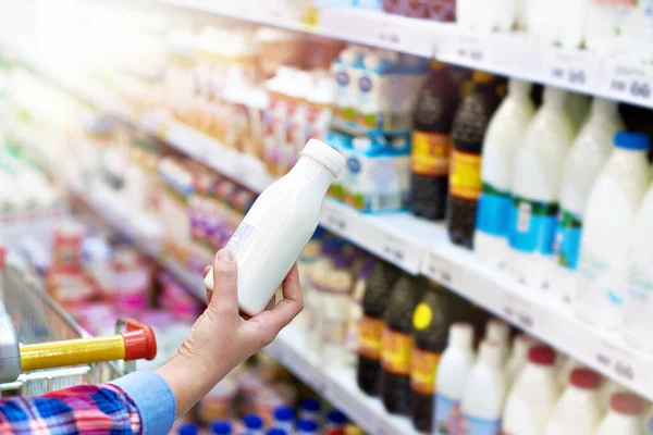 Vrouw en zuivelproduct in de winkel — Stockfoto