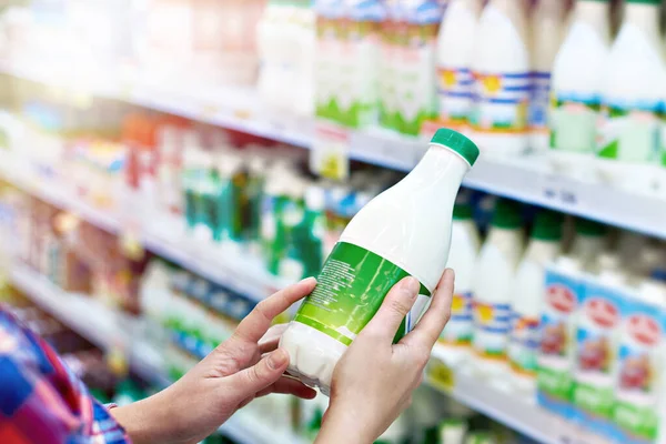 Vrouw met melk in de winkel — Stockfoto