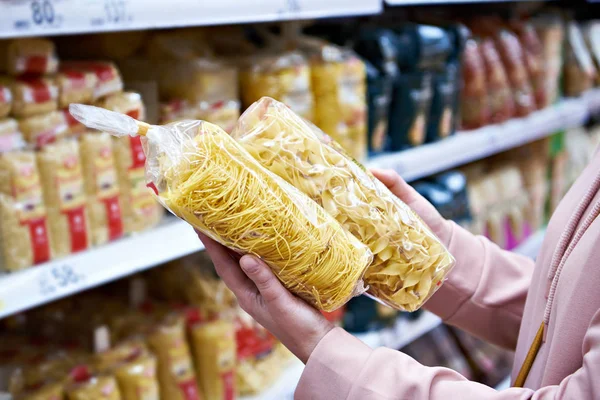 Жінка-покупець з пакетом макаронних виробів в магазині — стокове фото