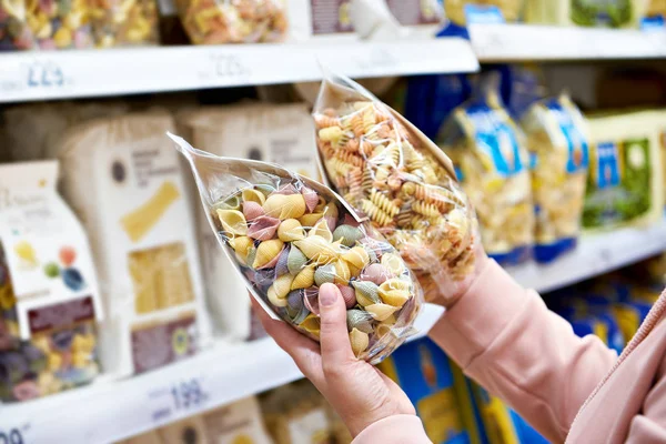 Vrouw met pakket pasta in winkel — Stockfoto