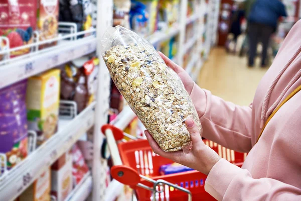 Muesli in handen van koper in de winkel — Stockfoto