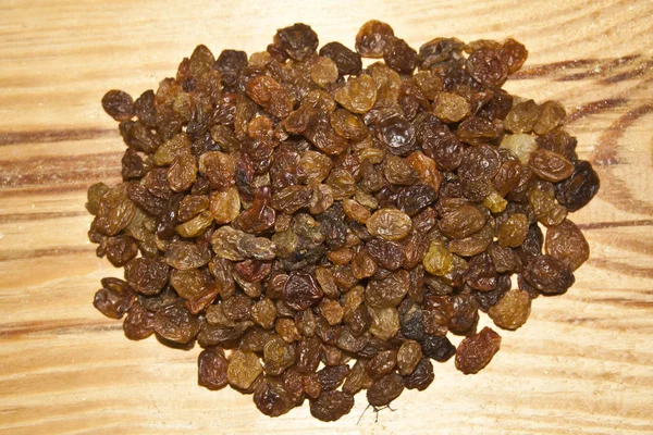 Kuru üzümler ahşap bir zeminde izole edilmiş.