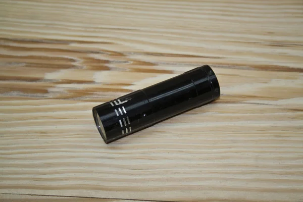 Flashlight isolated on a wooden background — Stock Photo, Image