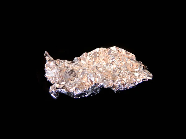 Crumpled foil isolated on black background — Stock Photo, Image