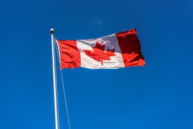 Mavi gökyüzü önünde Kanada Bayrağı 'nın yakın plan çekimi.