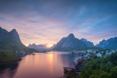 Norveç 'in Lofoten Adaları' ndaki Reine balıkçı köyünde gece yarısı güneşi ve gün batımı