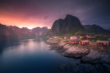 Norveç 'in Lofoten Adasındaki Hamnoy balıkçı köyünde gece yarısı güneşi ve gün batımı