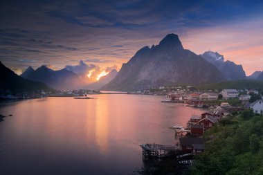 Norveç 'in Lofoten Adaları' ndaki Reine balıkçı köyünde gece yarısı güneşi ve gün batımı