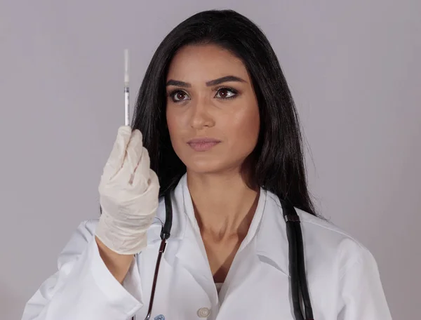 Bir şırınga izlerken çok esmer kadın doktor.