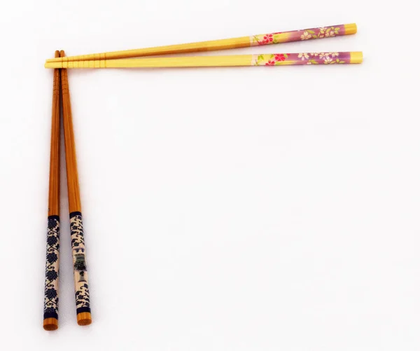 Beyaz bir arka plan üzerinde Asya yemek çubukları iki çift.