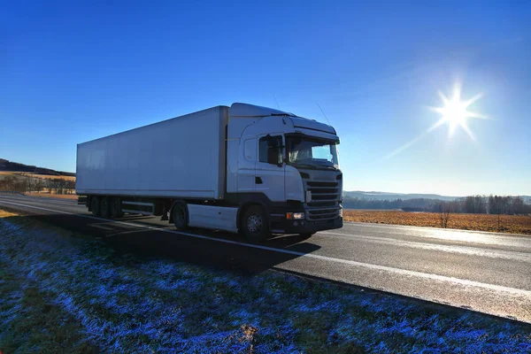 Lastbilstransporter på vägen vid solnedgången på vintern — Stockfoto